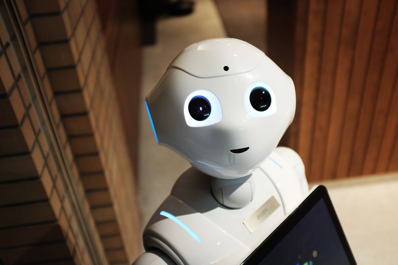 Services A futuristic humanoid robot in an indoor Tokyo setting, showcasing modern technology.