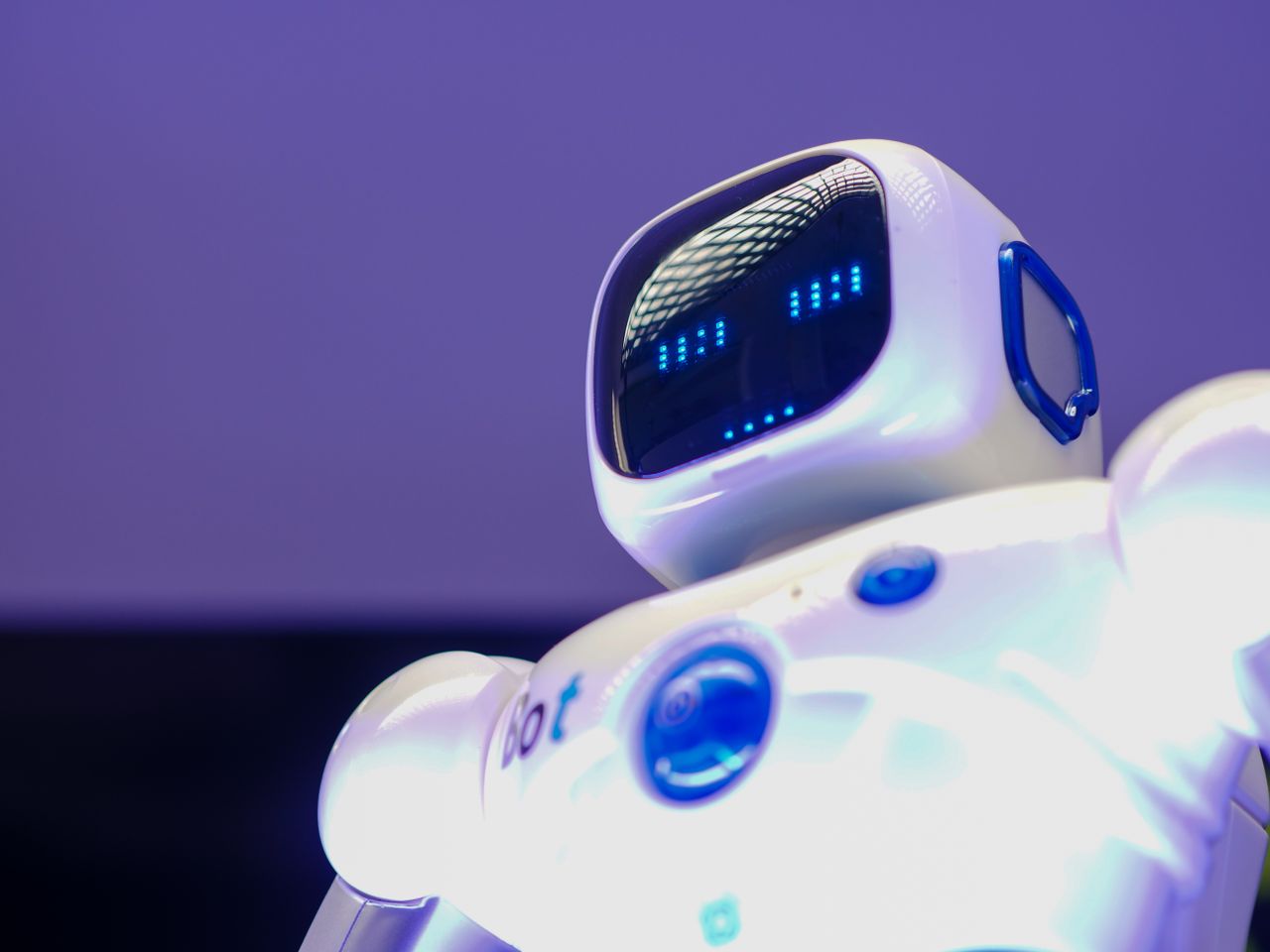 Services A modern humanoid robot with digital face and luminescent screen, symbolizing innovation in technology.